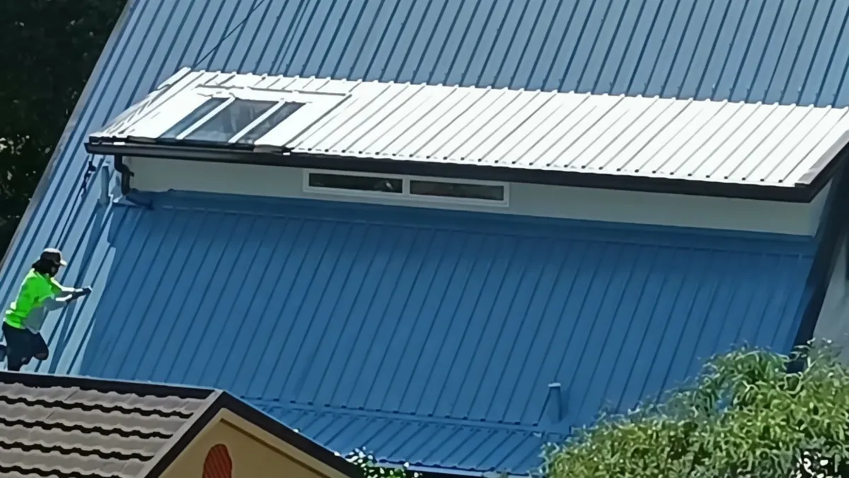 Specialist crew on steep mid-process corrugated roof in Rotorua during full restoration