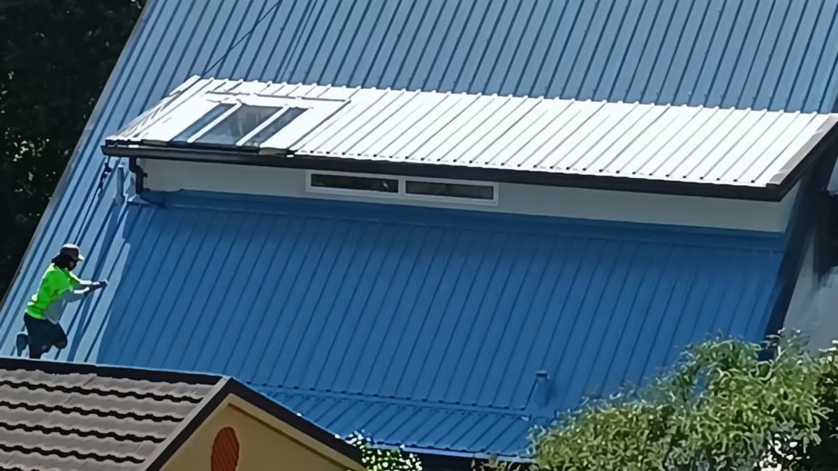 Specialist crew fastening on steep corrugated roof with Class 4 screw upgrade underway